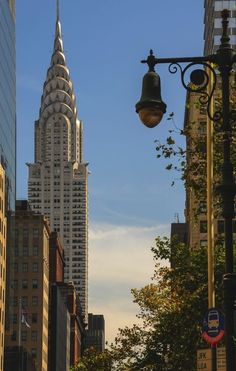 the empire building towering over new york city is seen in this view from across the street