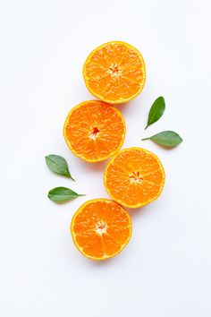 four oranges with leaves on top of them