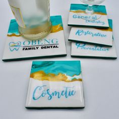 four coasters with blue and gold designs on them, one has a glass in the middle