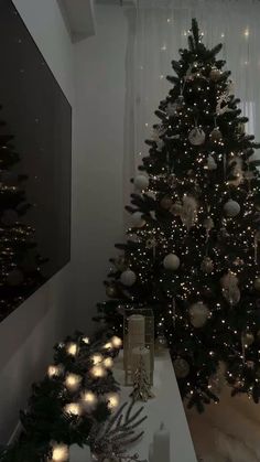 a decorated christmas tree in the corner of a room with white lights on it and other decorations