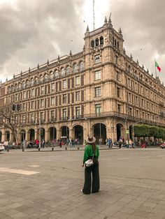 a woman standing in front of a large building