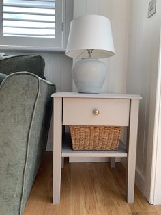 a white lamp sitting on top of a table next to a couch