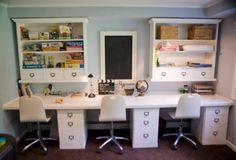 two white desks and chairs in a room with shelves on the wall behind them