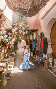 a woman is walking through an alley way