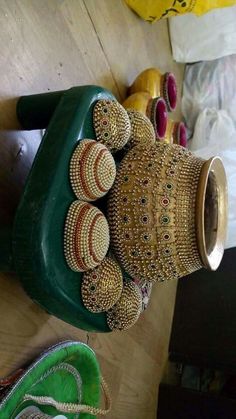 some shoes are laying on the floor next to a green pot with beaded decorations