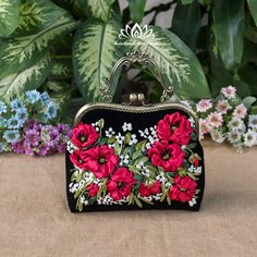 a black purse with red flowers on it