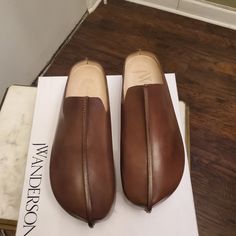 Brown Jw Anderson Clogs Size 39 Modern Brown Slip-on Clogs, Leather Sole Slip-on Clogs With Plain Toe, Modern Clogs With Leather Sole And Almond Toe, Modern Slip-on Clogs With Stitched Sole, Modern Slip-on Closed Toe Clogs, Modern Brown Clogs With Round Toe, Leather Sole Slip-on Clogs, Slip-on Clogs With Leather Sole, Slip-on Clogs With Stitched Sole And Closed Toe