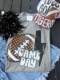 Get ready for the big game day with our Game Day Checkered Football Tee! The perfect shirt for any football fan, this tee features a fun checkered design that will make you stand out in the crowd. With its comfortable fit and stylish look, you'll be the envy of all your friends. Show off your team spirit and passion for the game in style! professionally printed tee brand: M&O Vintage Wash color: Grey comfy, unisex fit ships within 10-14 business days. Sporty T-shirt For Game Day During Football Season, Black Tops For Game Day, Collegiate T-shirt With Sublimation Print For Game Day, Team-colored Graphic T-shirt For Game Day, Team-colored Graphic Print T-shirt For Game Day, Game Day School Spirit T-shirt With Heat Transfer Vinyl, Sublimation Print Tops For Game Day Sports Season, Sports Fan T-shirt With Team Name For Tailgating, Sublimation Print Tops For Game Day