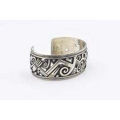 This is part of Chairish’s Costume Jewelry assortment.  This sterling silver overlay bracelet is in the Southwest Native American Style. I believe it is a Chinese import replica of a similar bracelet by Hopi silversmith Michael Kabotie.  It is stamped Sterling as well as with a raining cloud which is a Chinese fake Native American stamp.  Interior of the cuff measures 6" with an additional 1 1/4 " gap for a total circumference of 7 1/4".  Sterling Silver is relatively malleable, thus this cuff is adjustable. Width measures 2.72" straight across the widest part(from wrist bone to wrist bone). Bracelet face measures 1" tall (the face of the bracelet, north to south). Bracelet depth from top the underside of wrist is 2.12". Navajo Silver Jewelry, Bone Bracelet, African Jewellery, Silver Smithing, Native American Style, Southwest Style, Native American Fashion, African Jewelry, American Jewelry