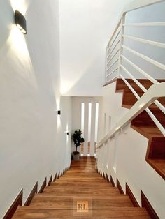 the stairs are made of wood and have white railings on each side, along with a potted plant