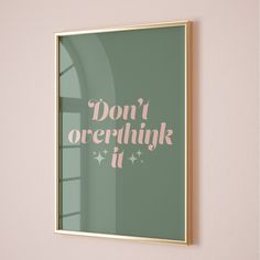 a pink and green poster with the words don't overthink it hanging on a wall