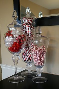 a large glass bowl filled with candy canes on top of a counter