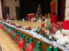 a long table covered in lots of christmas decorations and ornaments on top of wooden floors