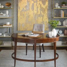 a table with a book on it sitting in front of shelves filled with vases and books