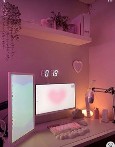 a desktop computer sitting on top of a desk next to a monitor and keyboard in front of a pink wall