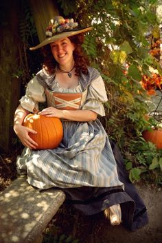 a woman sitting on a bench holding a pumpkin