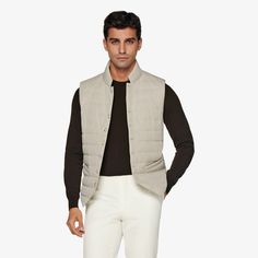 As an in-between layer or over a shirt, this sand padded vest is a versatile, trans-seasonal layering piece that effortlessly adds depth and casual appeal to any look. Classic Sleeveless Solid Outerwear, Casual Business Vest For Spring, Casual Business Casual Vest For Spring, Beige Outerwear For Layering, Casual Winter Vest For Business Casual, Casual Business Winter Vest, Winter Business Casual Vest, Versatile Vest For Layering, Sleeveless Vest For Business Casual Winter