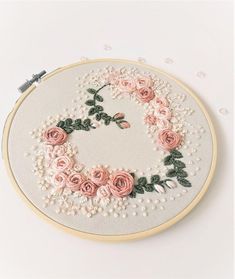 an embroidery project with pink roses and pearls