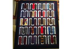 a quilt made to look like ties on a wall hanging from a door way in a house