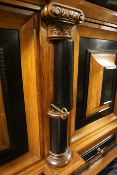 an ornate wooden grandfather clock on display in a museum case with black and gold trimmings