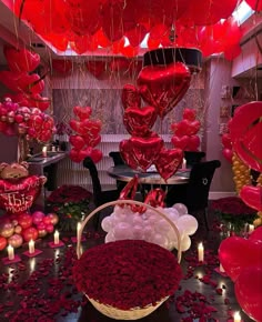 a room filled with lots of red balloons and hearts hanging from it's ceiling