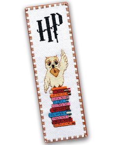 a cross stitch bookmark with an owl sitting on top of books that says harry potter