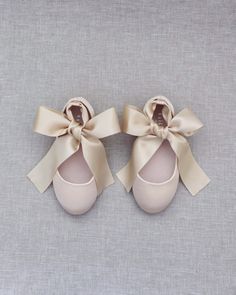 two pairs of baby shoes with bows on them