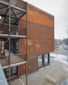 a building made out of shipping containers with stairs leading up to the top floor and second story