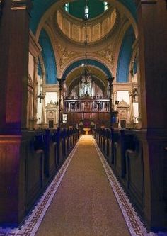 an empty church with pews and chandeliers on either side of the aisle