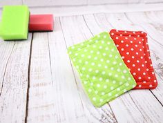 three pieces of cloth sitting next to each other on a white wooden floor with green and red squares