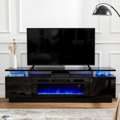 a television stand with a blue flame in the center and a black tv on top