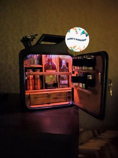 an open refrigerator with drinks inside in a dimly lit room, showing the door and shelves