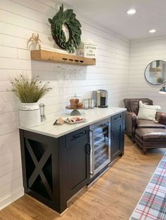 a living room filled with furniture next to a wooden floor and white painted wall behind it