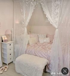 a white bedroom with a canopy bed and pink decor on the walls, along with two night stands