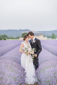 a bride and groom standing in a lavender field