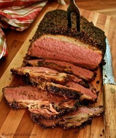 sliced meat sitting on top of a wooden cutting board