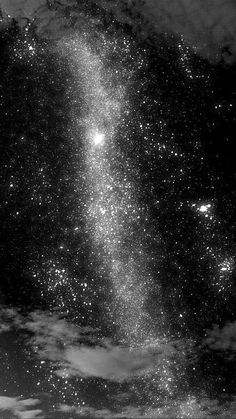 the night sky is filled with stars and clouds in black and white photo, as seen from space