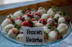 a glass platter filled with frozen hearts covered in strawberries