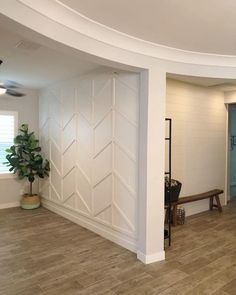 an empty room with white walls and wood floors