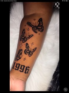 a woman's arm with butterflies on it and the word 2009 written in black ink