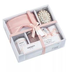 an open box with some items in it and a pink ribbon tied around the top