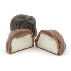 three pieces of chocolate covered in white and dark chocolate on a white background with one piece cut open