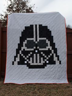 a star wars themed quilt hanging on a fence