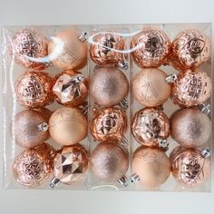 a box filled with lots of pink and gold christmas baubles on top of a table