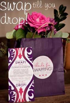 a purple shopping bag sitting on top of a wooden table next to a pink rose