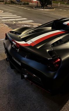 a black sports car with red and white stripes parked on the side of the road