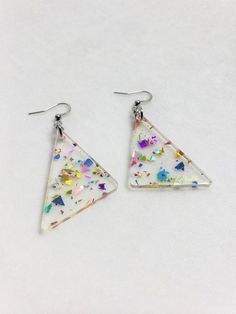 Choice of sterling silver .925 or surgical stainless steelApproximately 1.25" wide, and 2.5" long from top of metal hookInspiration straight from the 80s\90s, redesigned for the new retro look. These earrings are sure to sparkle, and packed full of rainbow fun! Made with a clear acrylic, and rainbow glitter that will differ in each earring, making them unique to you!This product is made to order, colors may appear slightly differentCare: the metal and acrylic can be cleaned with waterEach order Silver Triangle Earrings For Party, Silver Triangle Party Earrings, Triangle Silver Jewelry For Party, Rainbow Confetti, Earring Making, Retro Rainbow, Rainbow Glitter, New Retro, Triangle Earrings