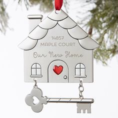 a house shaped ornament with a key hanging from it's front end