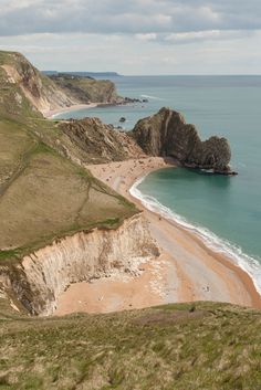 the beach is next to some cliffs and water