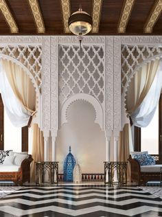 an ornate room with white walls and black and white checkered floor